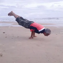 Here I am practicing Mayurasana, or Peacock Pose, on a quiet beach. This advanced arm balance builds strength and improves digestion. The sound of the waves and the sand beneath my hands makes the practice even more grounding.