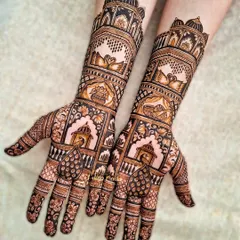 This design brings the grandeur of Rajasthani palaces to your hands. The henna features architectural jharokhas, graceful swans, and intricate peacock motifs, creating a truly royal look for a close family member.