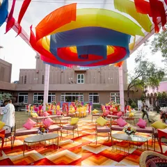 For a Mayra ceremony, we created a vibrant, colourful outdoor setup with quirky furniture and a rainbow of drapes, making the space feel like a carnival.