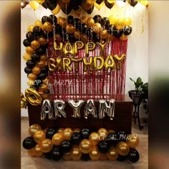 A classic and bold black and gold birthday theme. This setup includes a balloon arch over a red shimmer curtain, with the name spelled out in silver foil letters for a personalized touch.