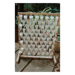 A creative and thoughtful detail for a Christian wedding. Cones filled with petals are ready for guests to shower the couple, displayed on a simple wooden stand.