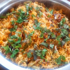 A large bowl of our vegetable biryani, garnished with fresh mint leaves and fried onions. We take pride in our commitment to taste and quality, even if we can't always show creativity in presentation.