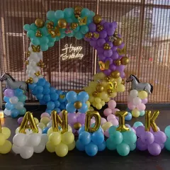A colorful and unique pony-themed first birthday for "Nandika". The decoration includes a balloon ring, pony foil balloons, a marquee number '1', and the name spelled out in balloon letters.