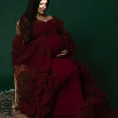A rich, deep red gown against a dark green backdrop creates a regal and luxurious feel. This is for the mama who wants to feel like a queen for her maternity shoot.