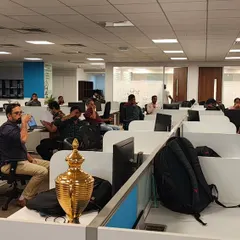 A wide view of a pranayama (breathing) session in an open-plan office, showing how easily these wellness practices can be integrated into the corporate environment.