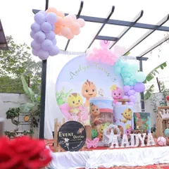 A bright and cheerful outdoor Cocomelon party for a third birthday. The pastel balloons and circular backdrop create a soft and inviting look that's perfect for toddlers.