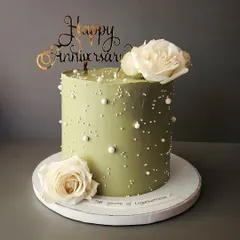 A pretty sage green cake for a special anniversary. This chocolate truffle cake is simple yet elegant, adorned with fresh white roses and delicate pearls.