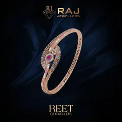 This stylish kada features a swirling design with a central ruby-colored stone, accented with the classic Greek key pattern. The combination of color and texture makes it a standout piece.