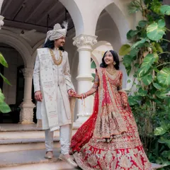 Descending the steps into their new life together. The bride's magnificent lehenga and the groom's proud glance create a moment of pure royal elegance at their destination wedding.