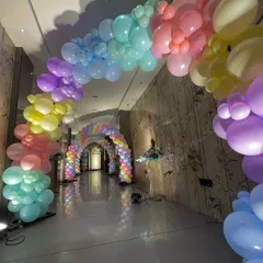 A long and impressive hallway transformed into a rainbow balloon tunnel, creating a stunning visual experience for guests as they enter the party.