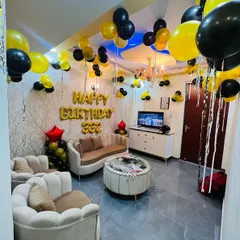 This wider view shows how the balloon decorations can transform an entire living room. Balloons on the ceiling and balloon pillars frame the seating area, creating a complete party zone at home.