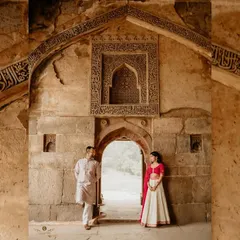 A beautifully framed shot of a couple within the archways of a historic ruin. The warm tones of the stone and their traditional attire create a regal and timeless pre-wedding portrait.