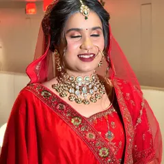 A joyful bride in a classic red velvet lehenga. It was an honor to be a part of her special day by providing this regal rental look.