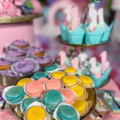 The carnival dessert table included a vibrant assortment of treats, like these colourful handcrafted macarons and mini donuts, all designed to match the party's pastel pink and teal colour scheme.