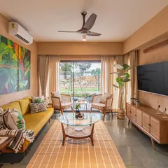 The living room of the Earth Villa, where lime-plastered walls create a warm, textured envelope. I selected mid-century modern furniture in natural wood and cane to complement the earthy aesthetic, while the large window frames a view of the surrounding landscape.