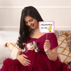 A sweet and happy moment, holding a 'Mommy to be' prop. This portrait captures the excitement and joy of the journey ahead.
