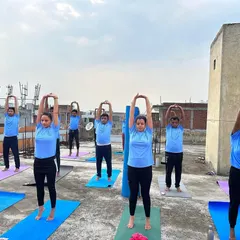 Students practicing Tadasana (Mountain Pose) with arms raised during our rooftop yoga session. Practicing outdoors adds a different energy to the asanas.