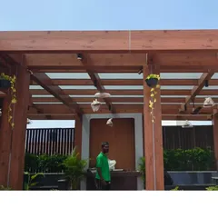 For a truly impressive transformation, I can design and install custom structures like this wooden pergola. It adds height, shade, and a framework for hanging plants, turning a simple terrace into an elegant outdoor room.