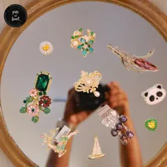 Our brooch collection is full of personality. Find your perfect match, whether it's a sparkling panda, a whimsical sailboat, a floral bouquet with an emerald green stone, or a pearl-adorned crown. These are pieces you won't find on Amazon.