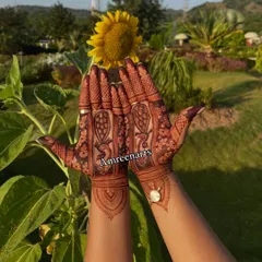 The beautiful result of natural henna and sunshine. This photo shows the deep reddish-brown stain of a peacock design, glowing in the natural light.