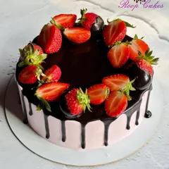 Sweet layers of chocolate and strawberry bliss. This cake features a rich chocolate drip over pink frosting, topped with fresh strawberries.