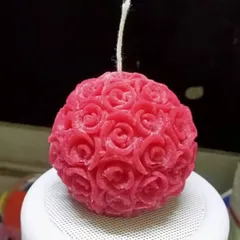 This is my rose ball candle, featuring dozens of tiny, detailed roses. It's a unique decorative piece that looks beautiful on its own or as part of a centerpiece.