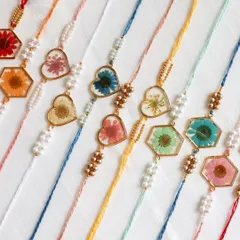 An assortment of my heart-shaped and hexagon-shaped floral rakhis, each one a tiny piece of wearable art.