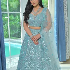 A full-length view of the sparkling powder blue lehenga. The complete set, including the diamond necklace and bracelets, creates a cohesive and glamorous look.