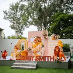 A "Lion King" themed first birthday party stage at The Backyard. The colorful backdrop, balloon arrangements, and character cutouts create a fun and immersive experience for the kids.