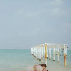 A serene moment on the white sands of Lakshadweep, with the iconic pier stretching into the turquoise sea. This wide shot emphasizes the beauty and seclusion of the destination.