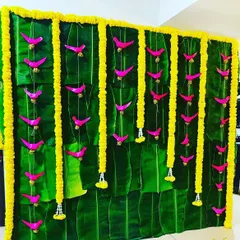 An eco-friendly backdrop made from fresh banana leaves, accented with marigold garlands and charming pink bird cutouts. This design is perfect for creating a traditional and vibrant South Indian theme.