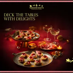 Deck the tables with delights. This image captures a festive Christmas spread with canapés and champagne, set in a warm, candlelit ambiance.