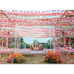 The breathtaking Haldi decor, with a canopy of colourful ribbons and flowers creating a vibrant and festive atmosphere for the outdoor celebration.
