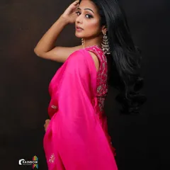 A dynamic pose from the same pink saree shoot, showing the movement of the fabric and highlighting the model's profile.
