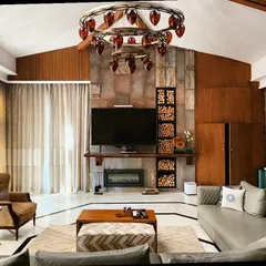 This living room is the heart of a renovated Haveli, where I blended rustic warmth with refined elegance. The exposed stone wall and wood paneling provide a tactile, earthy backdrop for modern furniture, all connected by a traditional brick archway that honors the home's heritage.