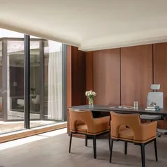 A director's cabin from our 'Layered Office' project, tailored to the user's taste. The design features rich wood paneling and a seamless connection to an outdoor courtyard, creating a spacious and personalized executive workspace that balances authority with comfort.