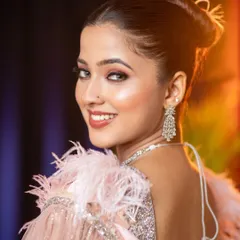 A beautiful example of a glamorous cocktail party look. The model's radiant smile, dewy skin, and soft glam makeup are perfectly paired with a feathered and sequined gown, demonstrating a look that is both elegant and commercially appealing.
