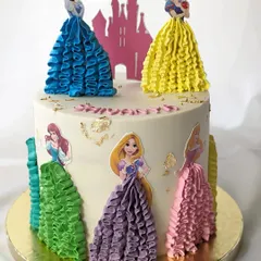 A princess cake with a creative twist. This design features beautiful piped buttercream ruffles to create the princesses' gowns, making the entire cake a work of art.