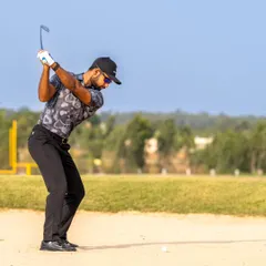 Escaping a bunker requires specific skills. Here, a golfer demonstrates the correct form for a sand shot, a technique we cover in our short game lessons.