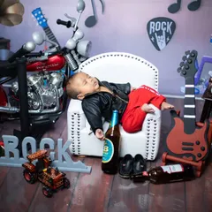 A classic 'love failure' scene, Sandalwood style. This little rockstar is sleeping it off after a long night, surrounded by guitars and his favourite beverages. It's a humorous take on newborn photography.