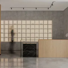 In this clinic, the careful choice of materials creates a lasting impression. The reception area uses a mix of light wood, a black marble accent cube, and a backlit display wall to create a space that feels clean, modern, and welcoming.