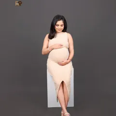For those who love a clean and contemporary look, our modern studio sessions are ideal. This portrait features a simple bodycon dress and a neutral backdrop, putting all the focus on the beautiful baby bump and the mother's serene glow.