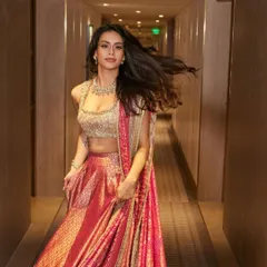 A candid, in-motion shot in a hotel corridor, capturing the beautiful movement and flow of the lehenga skirt.