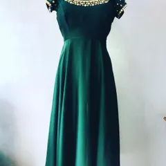 A simple yet beautiful dark green gown made from a plain saree. The custom look is elevated with a hand-embellished neckline and sleeves.