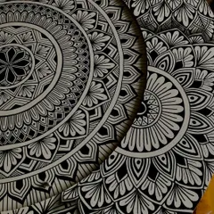 A close up of the details on the layered mandala. The design is split between two circular boards, creating a sense of depth and a crescent moon shape in the negative space.