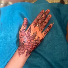 A beautiful and intricate party henna design covering the back of the hand. The pattern is a mix of floral and paisley motifs, perfect for any occasion.