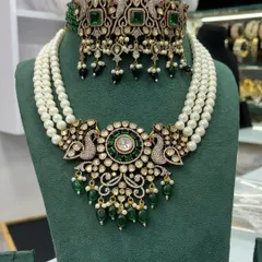 A unique rental set combining a peacock-motif choker with a multi-strand pearl necklace. The green stones and beads add a touch of colour.