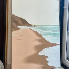 The full view of the large, vertical beach painting. This type of artwork can bring a sense of calm and escape to any room.