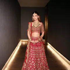 The full view of a stunning red and gold lehenga, styled to feel both regal and comfortable. This is how you own the hallway before you even walk down the aisle.