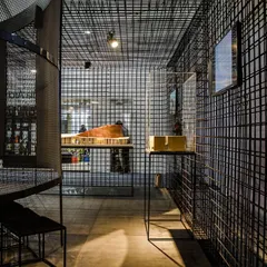 For an exhibition at India Arch Dialogue, we used black steel mesh to create porous, transparent walls. This material choice defines the space without creating solid barriers, allowing for visual connection throughout.